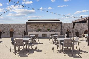 A patio with tables and chairs and a wall with tiles.